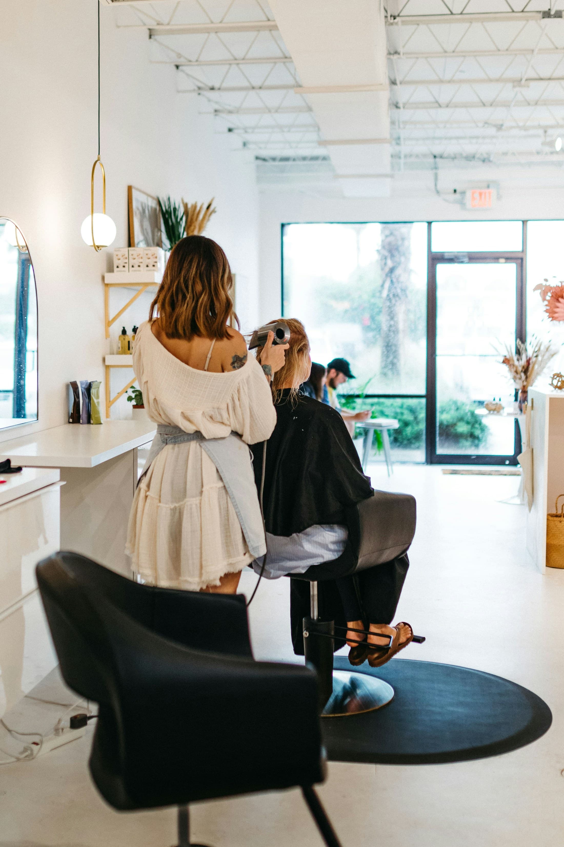 Stylist finishing a guest's hair in a salon chair